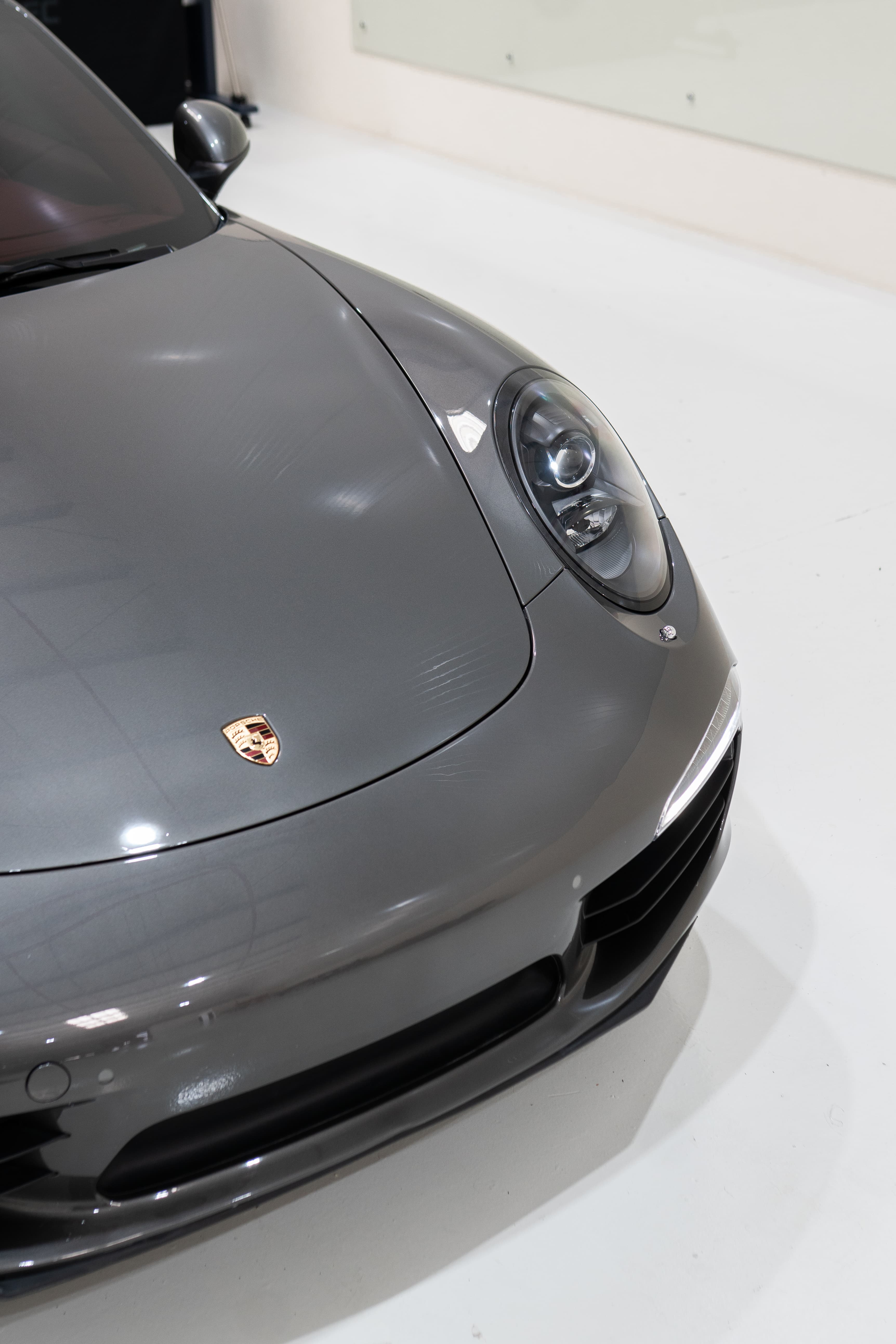 Porsche 911 front fender and headlight showing ceramic-coated paint clarity